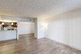 Located at 8601 Roberts Dr in Sandy Springs, GA, this two-bedroom, two-bathroom single-floor residence offers a well-organized layout designed for comfortable everyday living. The living area is bright and open, featuring durable wood-style flooring and a textured ceiling, with a sliding glass door providing direct access to an outdoor patio and allowing natural light to fill the space. The layout flows seamlessly into a dining area and galley-style kitchen, which is equipped with dark espresso cabinetry, granite countertops, stainless steel appliances including a refrigerator, dishwasher, microwave, and electric range, plus pendant lighting that adds a polished touch. Both bathrooms echo the kitchen's aesthetic with matching granite countertops and dark wood vanities. The primary bathroom features a tub-shower combination with tile surround, while the second bathroom also includes a full tub and shower. The two bedrooms are carpeted for comfort and each includes a window with natural outdoor views and a dedicated closet. Two hallways provide convenient circulation throughout the home. The overall ambiance is clean, neutral, and move-in ready, presenting a practical and cohesive design throughout.
