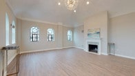 This thoughtfully designed single-floor residence combines classic architectural details with modern finishes to create an elegant and functional living environment. The expansive main living area immediately impresses with its soaring vaulted ceilings, a striking sputnik chandelier, and a row of signature arched windows with black metal frames that flood the space with natural light. A refined marble-surround fireplace serves as the room's focal centerpiece, complemented by light wood-look tile flooring that flows throughout. The open layout connects seamlessly to a well-appointed kitchen, featuring white shaker cabinetry, dramatic marble-veined quartz countertops, a large center island with pendant lighting, subway tile backsplash, and stainless steel appliances — all framed by wide windows overlooking the surrounding area. The bedroom wing offers generously proportioned rooms with plush carpeting, ceiling fans, and access to outdoor areas via black-framed glass doors. A spacious walk-in closet provides ample built-in clothing storage. The bathrooms are finished to a high standard, showcasing slate-toned large-format tile flooring, white vanities with marble countertops, soaking tubs with marble surrounds, and distinctive arched windows that bring in natural light. Throughout, the neutral color palette and refined finishes create a cohesive, sophisticated ambiance.