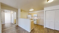 Located at Fountain Springs Grove in Colorado Springs, CO, this two-bedroom, two-bathroom residence offers a practical and comfortable single-floor layout. The open-concept kitchen and living area serves as the heart of the home, featuring light wood-toned cabinetry, white appliances including a refrigerator, electric range, and built-in microwave, as well as wood-style flooring that extends throughout the main living spaces. A peninsula counter provides additional prep space and defines the transition between the kitchen and living room. The living room is bright and airy, with a sliding glass door dressed in vertical blinds that opens to an outdoor area and fills the space with natural light. Both bedrooms are generously proportioned, with soft carpeting underfoot and large windows that invite plenty of daylight and offer neighborhood views. The primary bedroom is a comfortable retreat with ample space. Each of the two bathrooms includes a full tub-shower combination with white tile surround and chrome fixtures. A dedicated closet provides added storage. The neutral color palette throughout creates a clean, cohesive atmosphere well-suited to a variety of furnishing styles.