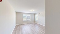 This single-floor unit offers a well-organized and functional layout designed for comfortable everyday living. Throughout the space, light hardwood-style flooring and neutral beige walls create a bright, cohesive aesthetic that feels open and welcoming.

The living area is generously proportioned, featuring multiple windows fitted with horizontal blinds that allow for abundant natural light and views of the surrounding outdoor greenery. Wall-mounted vents and a thermostat reflect practical climate control throughout.

The kitchen is equipped with warm honey-toned wood cabinetry providing ample storage, a double-basin sink, a full suite of white appliances including a refrigerator, electric range with overhead microwave, and dishwasher. A peninsula counter extends into the space, offering additional workspace and a natural transition to the living area.

The bedrooms are well-sized, each with light flooring, neutral walls, and windows that bring in natural light. At least one bedroom includes a dedicated closet with a hanging rod, offering practical storage. An additional room also benefits from natural light via exterior-facing windows.

The bathroom features warm-toned tile flooring, clean white fixtures, and a towel bar, maintaining the unit's consistent, functional design. Overall, the space presents a clean, move-in-ready environment with a bright and neutral palette throughout.
