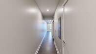 Located at 55 SW Ottawa Ave in downtown Grand Rapids, Michigan, this one-bedroom, one-bathroom unit offers a well-organized and efficiently designed layout across a single floor. The space features a contemporary aesthetic throughout, with a neutral gray and white color palette complemented by modern finishes.

The kitchen serves as a standout feature, boasting dark granite-style countertops, crisp white cabinetry with sleek hardware, a classic subway tile backsplash, and a full suite of stainless steel appliances including a refrigerator, electric range, and built-in microwave. A peninsula with an undermount sink provides additional prep space and adds an open feel to the area.

A clean, well-lit hallway connects the main living areas to the private spaces, featuring recessed lighting and dark tile flooring that adds a polished touch. The bedroom is a comfortable, carpeted retreat with soft gray walls, ample natural light, and direct access to a dedicated closet, providing practical storage.

The bathroom is finished with white cabinetry, dark countertops matching the kitchen, chrome fixtures, and a full tub/shower combination — maintaining a cohesive design throughout. The overall ambiance of this unit is clean, modern, and functional, making it a practical urban living option in the heart of Grand Rapids.