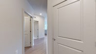 Located in La Plata, MD, this well-appointed 3-bedroom, 3-bathroom residence offers a thoughtfully designed single-floor layout that balances comfort and functionality. The entrance welcomes you into a bright, open-concept living, dining, and kitchen area finished with light hardwood-style flooring that flows seamlessly throughout the main spaces. The kitchen is a standout feature, showcasing gray shaker-style cabinetry reaching to the ceiling, white quartz countertops, a classic subway tile backsplash, stainless steel appliances including a refrigerator, range, and microwave, plus a large island with an undermount sink and elegant pendant lighting. The living area is filled with natural light from oversized windows and is accented by a ceiling fan. The spacious primary bedroom offers sweeping outdoor views through large corner windows, plush carpeting, and a generous walk-in closet with built-in wire shelving. The two additional bedrooms are carpeted and well-lit, each with ceiling fans and ample closet access. All three bathrooms feature gray vanities with white countertops and wood-look tile flooring. A dedicated in-unit laundry room with side-by-side washer and dryer adds everyday convenience. Four closets throughout provide excellent storage capacity.