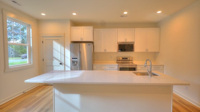 Chef's kitchen with eat in island, quartz countertops and stainless appliances. - 345 W Stewart Ave