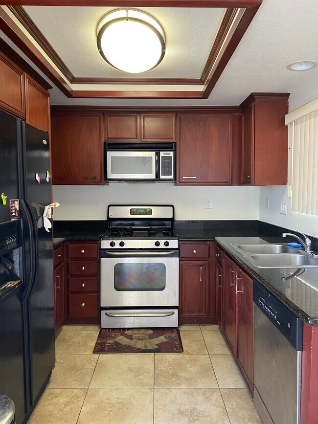 Cocina: Amplio espacio en gabinetes y electrodomésticos incluidos. - 408 N Imperial Ave