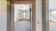 Located at 1234 S King St in Seattle, WA, this 4-bedroom, 1-bathroom unit offers a practical and well-organized single-floor layout. The space features classic craftsman-inspired architectural details, including wood-trimmed doorways, panel doors with transom windows, and warm wood baseboards throughout.

The kitchen is a functional highlight, equipped with warm oak cabinetry, granite-style countertops, a gas range, dishwasher, and refrigerator. A distinctive checkered tile floor adds character, while two windows and a door provide ample natural light and outdoor views of the surrounding neighborhood. A pendant light fixture completes the kitchen's welcoming ambiance.

The four bedrooms are carpeted and finished with neutral walls, offering a clean and versatile canvas. Each room benefits from natural light through windows fitted with blinds, with views of surrounding greenery and the Seattle streetscape. The primary bedroom is notably spacious, with room for generous furniture arrangements.

The bathroom is well-appointed with a full tub-shower combination, vanity, and checkered tile flooring consistent with the unit's design language. Grab bars provide added accessibility.

Two hallways connect the rooms efficiently, contributing to a logical and flowing floor plan. Throughout the unit, the consistent use of warm wood tones and light neutral walls creates a cohesive and comfortable living environment.