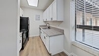 Located at 5100 Leetsdale Dr in Denver, Colorado, this 710-square-foot apartment offers a practical and modern single-floor layout with 2 bedrooms and 2 bathrooms. Throughout the unit, light-toned hardwood-style flooring provides a clean, cohesive look against crisp white walls and bright white baseboards.

The kitchen features white shaker cabinetry, granite-style countertops, a black matte faucet, and black appliances, including a refrigerator and range. A window with blinds allows natural light into the space. The living area is open and airy, equipped with a ceiling fan with light fixture, a wall-mounted air conditioning unit, and a baseboard heating system, ensuring year-round comfort. Windows fitted with blinds offer views of the surrounding neighborhood.

The primary bedroom spans 180 square feet and shares the same hardwood-style flooring and ceiling fan found throughout the unit. Both bathrooms are finished with granite-style countertops, white shaker vanity cabinets, and matte black hardware and fixtures. One bathroom includes a soaking tub with a curved shower rod. A dedicated hallway laundry closet houses a stacked washer and dryer, adding everyday convenience to this well-appointed Denver apartment.