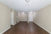 This single-story home on Eastwyck Circle in Decatur, Georgia offers a well-organized layout with a neutral color palette of warm beige tones throughout. The living area features rich, dark wood-look flooring and receives natural light through a sliding glass door fitted with vertical blinds, creating a bright and open atmosphere. An adjacent dining area flows seamlessly toward the kitchen, maintaining the same hardwood-style flooring for a cohesive feel.

The kitchen is equipped with white cabinetry, granite-look countertops, a white subway tile backsplash, a double-basin sink, a dishwasher, and an electric range. Upper and lower cabinets provide ample storage throughout.

The bedrooms are carpeted in a neutral tan tone and feature windows that bring in natural light and outdoor views of surrounding greenery. Several bedrooms include closets with bi-fold doors, offering practical storage. One bedroom benefits from two windows, enhancing ventilation and brightness.

The bathrooms are finished with light ceramic tile flooring and a striking dark wood-look tile surround in the tub-shower combination, adding a bold design contrast. One bathroom includes a vanity with a medicine cabinet mirror and brushed nickel fixtures, completing the updated look throughout the home.