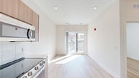 Located at 130 W Girard Avenue in Philadelphia's vibrant Northern Liberties neighborhood, this thoughtfully designed one-bedroom, one-bathroom unit offers a clean, modern aesthetic throughout. Light wood-tone flooring runs continuously across the open-plan living and kitchen area, creating a warm and cohesive feel that is further enhanced by recessed lighting and crisp white walls.

The kitchen is outfitted with flat-front wood cabinetry extending to the ceiling, white quartz countertops, a classic subway tile backsplash, and a full suite of stainless steel appliances including a gas range, dishwasher, built-in microwave, and refrigerator. The open layout allows the kitchen to flow seamlessly into the living area, which is bathed in natural light from a sliding glass door that opens onto a private balcony with open views of the Philadelphia cityscape.

The bedroom is a well-proportioned, serene retreat featuring a dedicated window for natural light and access to a walk-in closet with built-in shelving. The bathroom continues the modern design language with large-format tile flooring, a wall-mounted wood vanity, an arched mirror, and a glass-enclosed shower. Additional conveniences include in-unit laundry and two closets for ample storage.