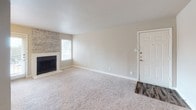 Located at 18175 Midway Rd in Dallas, TX, this single-floor unit offers a well-organized and functional layout throughout. The living room serves as a welcoming focal point, featuring plush carpeting, a striking stone-accented fireplace, and a front entry door, all bathed in natural light from a window with blinds. The textured ceiling adds a classic touch to the space.

The kitchen is thoughtfully appointed with white cabinetry, dark countertops, and black appliances including a refrigerator and electric range. Wood-look vinyl flooring and a bright window overlooking greenery give the kitchen a clean, practical feel.

The bedroom is a comfortable, carpeted retreat enhanced by a ceiling fan with light fixture and a window that invites natural light. The room provides ample space for furnishings and personal use.

The bathroom features wood-look vinyl flooring and is equipped with ADA-compliant grab bars near the toilet and along the wall, reflecting thoughtful accessibility design. A vanity with storage is also present in the space.

Overall, the unit presents a neutral, move-in ready palette with a combination of carpet and vinyl flooring, consistent white trim throughout, and practical finishes that make it a comfortable and accessible living space in the Dallas area.