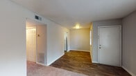 Located at 1015 Glendale Dr in Greensboro, NC, this single-floor unit offers a practical and well-organized layout suited for comfortable everyday living. The entryway opens into a combined living and dining area that features a mix of durable wood-look plank flooring and plush carpeting, with a window providing natural light and a view of the surrounding neighborhood. The textured ceilings are consistent throughout the unit, adding a classic residential character to each room. The galley-style kitchen is efficiently designed, featuring gray cabinetry with ample upper and lower storage, a double-basin stainless steel sink with countertop space on either side, and white appliances including a refrigerator, electric range, and dishwasher. The wood-look flooring continues through the kitchen, creating a cohesive flow from the living areas. The bedrooms are carpeted and finished with neutral gray walls, offering a calm and versatile space. One bedroom includes a window with blinds that brings in natural light. The bathroom is equipped with a full-size soaking tub and shower combination, accented by chrome fixtures and a towel bar. Flush-mount ceiling lighting is present throughout, and HVAC vents are conveniently placed for year-round climate comfort.