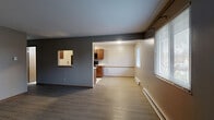 Located at 1820 Garden Ridge Dr in Toledo, OH, this 2-bedroom, 1-bathroom unit offers a practical and comfortable single-floor layout. The open-concept living and dining area is finished with durable wood-tone luxury vinyl plank flooring and neutral gray walls, creating a clean, move-in-ready aesthetic. Windows fitted with blinds allow natural light to filter in, while baseboard heating units run along the perimeter walls. A pass-through window connects the living area to the kitchen, enhancing the sense of openness between spaces. The galley-style kitchen is well-equipped with warm wood cabinetry, light countertops, a double-basin sink, and a full suite of black appliances including a refrigerator, electric range, and over-the-range microwave. Light tile flooring completes the kitchen's functional design. The primary bedroom offers a comfortable footprint with LVP flooring, a window for natural light, and closet access. The second bedroom mirrors a similar layout. The full bathroom features soft green walls, a single-sink vanity with wood cabinetry, and a full tub-shower combo. Four closets throughout the unit provide ample storage. The overall layout is efficient and well-organized, suited for everyday living.