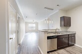 Located at 1069 Chateau Crossing Dr in Fort Mill, SC, this well-appointed 2-bedroom, 2-bathroom residence offers a thoughtfully designed single-floor layout. The open-concept living and kitchen area serves as the heart of the home, where wood-style flooring, crown molding, and a ceiling fan create a bright, welcoming atmosphere. Natural light flows in through large windows, enhancing the airy feel of the space.

The kitchen is equipped with dark espresso cabinetry, granite countertops, and a full suite of stainless steel appliances, including a refrigerator, range, microwave, and dishwasher. A peninsula with pendant lighting provides additional counter space and casual seating, seamlessly connecting the kitchen to the living area.

The spacious primary bedroom features crown molding, a ceiling fan, and hardwood-style flooring, along with a dedicated closet. The second bedroom is carpeted and bright, with a window offering natural light. Both bathrooms are finished with dark vanity cabinetry, white countertops, and wood-style tile flooring. A dedicated laundry room with wire shelving and washer/dryer hookups adds everyday convenience. Two closets provide ample storage throughout the home.