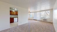 Located at 6350 Stumph Rd in Parma Heights, Ohio, this single-floor unit offers a practical and comfortable layout with well-defined living spaces throughout. The generously sized living room is carpeted and filled with natural light streaming through large floor-to-ceiling windows dressed with vertical blinds, offering pleasant outdoor views of surrounding trees. A ceiling fan adds to the room's comfort, while baseboard heating ensures warmth throughout the colder months. The living area flows openly toward the entry foyer, which features durable hardwood-style flooring. Adjacent to the living room, the kitchen is equipped with warm-toned wood cabinetry, granite-style countertops, a white electric range, a dishwasher, and light tile flooring, providing a functional cooking space. The bedroom is a calm, carpeted retreat with a window framing natural outdoor scenery and baseboard heating along the wall. A pair of six-panel double doors leads to a closet, offering ample storage. The bathroom is finished with white subway tile walling, a white vanity with modern hardware, wood-look flooring, and a bathtub, presenting a clean and classic aesthetic. Overall, the unit delivers a straightforward, well-maintained living environment in a convenient Parma Heights location.