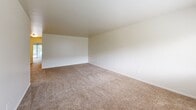 Located at 1600 Laurel Rd in Lindenwold, NJ, this single-floor residence offers a practical and comfortable layout with two bedrooms, two bathrooms, a living room, and a dedicated kitchen. The interior is finished with neutral, light-toned walls throughout, creating a clean and bright atmosphere. Plush wall-to-wall carpeting runs through the living areas and bedrooms, adding warmth underfoot, while the kitchen and bathrooms feature easy-to-maintain tile flooring. The living room is a generously sized space with a large window that invites natural light and offers views of surrounding greenery, with direct access to the unit's entry door. The spacious primary bedroom includes a window overlooking outdoor foliage and benefits from an angled ceiling that adds architectural interest. The kitchen is well-equipped with warm wood cabinetry, dark granite-style countertops, and white appliances including a gas range, dishwasher, and refrigerator, all under bright overhead lighting. The bathrooms are finished in neutral tones, with one featuring a full tub-and-shower combination accented by classic tile surround and a mosaic tile floor. Two closets and a connecting hallway complete the thoughtful layout of this residence.