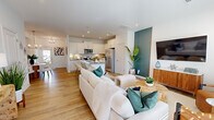 This two-story home on Barwell Dr in Charlotte, NC offers a well-designed layout across two floors. The main floor features an open-concept living, dining, and kitchen area unified by light hardwood flooring and recessed lighting throughout. The living room is bright and welcoming, with natural light flowing in from a front-facing entry and windows. A teal accent wall adds a bold architectural detail that visually connects the dining area and kitchen, while a modern chandelier anchors the dining space.

The kitchen is outfitted with white shaker cabinetry, granite countertops, a subway tile backsplash, stainless steel appliances, and a central island with bar seating — ideal for both cooking and casual dining.

Upstairs, the primary bedroom is generously proportioned, featuring a tray ceiling, large windows with outdoor views, and plush carpeting. The primary bathroom includes a dual-sink vanity with white cabinetry and direct access to a walk-in closet equipped with wire shelving. Two additional bedrooms provide flexible space for various needs. A dedicated laundry area with a full-size washer and dryer adds everyday convenience. The home presents a clean, modern aesthetic throughout.