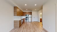 This 1-bedroom, 1-bathroom unit at 3214 Broadway Ave in Everett, Washington offers a well-designed, modern layout across a single floor. The open-concept living area seamlessly integrates the kitchen, dining, and living spaces, creating an efficient and inviting atmosphere filled with natural light from large windows.

The kitchen is a standout feature, outfitted with warm wood-tone flat-panel cabinetry that extends to the ceiling for generous storage, white tile backsplash, light stone countertops, and a full suite of stainless steel appliances including a refrigerator, range, microwave, and dishwasher. Light hardwood-style flooring runs throughout the entire unit, lending a clean, cohesive look.

The living area benefits from a ceiling fan and a large window overlooking the surrounding neighborhood, while recessed lighting provides consistent illumination throughout the main space. The bedroom is a comfortable size, featuring its own ceiling fan, a window with outdoor views, and access to closet space. Three closets throughout the unit offer ample storage.

The bathroom is cleanly finished with matching light flooring, a wood-tone vanity, and bright white walls. The unit's modern, neutral palette and quality finishes make it a functional and stylish home in Everett, WA.