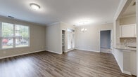 This single-floor, 3-bedroom, 2-bathroom home offers a comfortable and functional layout with modern finishes throughout. The open-concept kitchen and living area serves as the heart of the home, featuring wood-look plank flooring, crown molding, and a stylish chandelier. The kitchen is well-equipped with white cabinetry, granite-style countertops, stainless steel appliances including a range, microwave, and refrigerator, plus a built-in wine rack and a pantry with louvered doors. The living and dining areas are bright and spacious, with natural light streaming through multiple windows and French doors fitted with blinds, along with a built-in shelving nook that adds character and storage.

The three bedrooms are carpeted for comfort. The primary bedroom is generously sized and includes a walk-in closet with wire shelving. The additional bedrooms feature plush carpet and windows with pleasant outdoor views. Both bathrooms are well-appointed; one includes a full tub-shower combination, a white vanity with a light stone countertop, and durable wood-look flooring. A dedicated utility room and closet round out the layout. Crown molding and neutral warm-toned walls create a cohesive, inviting ambiance throughout the entire home.