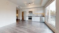 Located in the vibrant SoMa neighborhood of San Francisco, this thoughtfully designed studio on Harrison Street offers a modern, open-concept layout that maximizes every inch of its well-appointed floor plan. Light gray hardwood flooring flows throughout the main living area, complemented by crisp white walls and track lighting that gives the space a bright, airy feel. Large sliding windows flood the interior with natural light while framing views of the lively streetscape below.

The kitchen is a standout feature, boasting full-height white cabinetry, dark countertops, a marble-style tile backsplash, and a complete suite of stainless steel appliances — including a French door refrigerator, range, microwave, and dishwasher. The open design allows the kitchen to flow seamlessly into the living area, making the space feel expansive and functional.

The bathroom is elegantly finished with large-format marble-patterned wall tiles surrounding a soaking tub and shower combination. Brushed gold fixtures add a touch of warmth and sophistication against the clean white palette. A hallway provides a natural transition between the living space and bathroom, adding a sense of structure to the open layout. This studio combines modern urban living with refined finishes in one of San Francisco's most dynamic neighborhoods.