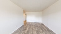 Located in Phoenix, AZ, this efficiently designed one-bedroom, one-bathroom unit offers a clean, modern aesthetic throughout its single-floor layout. Wood-look plank flooring runs consistently through every room, lending warmth and cohesion to the overall design.

The open living area is bright and airy, with neutral white walls, clean lines, and a window that invites natural light while offering views of the surrounding neighborhood. The space flows naturally into the kitchen and dining area, which is equipped with crisp white shaker-style cabinetry, granite-style countertops, a white range, and ample storage. A ceiling fan overhead adds comfort to the dining space, and a window provides additional natural light.

The bedroom is a comfortable, well-proportioned retreat featuring a tall, narrow window dressed with blinds, textured ceiling detail, and generous wall space. A dedicated closet provides practical storage. The bathroom is clean and functional, with a white vanity featuring modern hardware, a tiled tub and shower combination, and consistent wood-look flooring that ties it seamlessly to the rest of the unit.

Overall, the unit presents a fresh, move-in-ready atmosphere with a neutral palette, updated finishes, and a practical layout well-suited to everyday living in the Phoenix area.