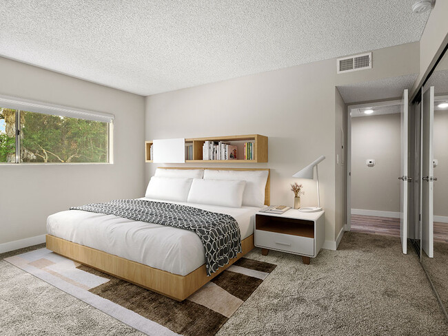 Carpeted bedroom with large window for natural light. - Sherman Oaks Gardens