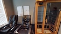 Located in Jefferson, this single-floor wellness retreat is thoughtfully designed to provide a calming environment for rest and recovery. The space centers around a theme of mindful relaxation, as reflected in the "inhale" and "exhale" wall art that sets a tranquil tone upon entry. The interior features plush, full-body massage chairs that invite guests to unwind in comfort, positioned alongside a compact infrared sauna unit with a glass-paneled door and a digital control panel for a personalized heat therapy experience. The neutral-toned walls and understated décor create a clean, spa-like ambiance that encourages focus and peace of mind. The layout is efficient yet welcoming, making the most of the available floor space without feeling cluttered. Whether visiting for targeted muscle relief through the massage chairs or seeking the detoxifying benefits of infrared heat, this wellness space offers a well-curated selection of therapeutic amenities. Its straightforward, no-frills design keeps the emphasis firmly on the guest experience, making it an accessible and purpose-driven destination for those seeking restorative self-care.