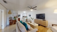 Located at 1015 Spanish River Rd in the heart of Boca Raton, Florida, this single-floor residence exudes a relaxed coastal charm throughout its thoughtfully designed layout. The open-concept living and dining area serves as the centerpiece of the home, featuring crisp white walls, tile flooring, and a ceiling fan that enhances the airy atmosphere. Coastal-inspired décor, including teal accents and natural wood furnishings, ties the space together seamlessly, while the adjacent dining area with white bistro-style chairs adds a casual elegance.

The galley kitchen is both functional and stylish, outfitted with white cabinetry, stainless steel appliances, rich granite countertops with a warm gold-and-brown tone, and a tile backsplash that complements the overall palette. Natural light filters in through a window at the end of the kitchen, brightening the space.

The bedrooms are well-proportioned and serene, each featuring tile flooring, ceiling fans, and natural light from large windows with vertical blinds. The primary bedroom includes crown molding and direct access to additional spaces within the home.

The bathroom features granite countertops, a framed mirror, and a tub-shower combination with a decorative curtain. A dedicated vanity area with a granite countertop, track lighting, and a large mirror adds a refined touch to the home's interior.