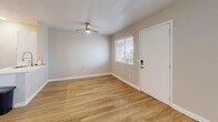 Located at 60 W Stone Loop in Tucson, Arizona, this efficiently designed single-floor studio offers a clean, modern aesthetic with thoughtful use of space. Warm-toned luxury vinyl plank flooring runs throughout, complementing the soft neutral wall palette and crisp white baseboards that give the unit a bright, cohesive feel.

The open-concept kitchen and living area forms the heart of the space. The kitchen is outfitted with white shaker-style cabinetry, white quartz countertops, a subway tile backsplash, and a full suite of stainless steel appliances including a refrigerator, electric range, and over-the-range microwave. A peninsula counter provides additional prep space and visually separates the kitchen from the living area. Recessed lighting ensures the kitchen is well-lit, while a ceiling fan with integrated lighting serves the living area. A window with blinds allows natural light to filter in, and a keypad-secured entry door adds a modern convenience.

The bathroom is finished with white subway tile surrounding the tub-shower combo, a white vanity with a single sink, and coordinating wood-look flooring, creating a clean and functional space. A dedicated closet provides practical storage. The overall design prioritizes functionality and modern simplicity, making this Tucson studio an efficient and well-appointed living space.