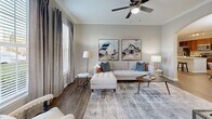 Located at 1525 Station Center Blvd in Suwanee, GA, this thoughtfully designed single-floor residence offers 2 bedrooms, 3 bathrooms, a dedicated office, and generous living spaces. The open-concept kitchen is a standout, featuring rich cherry wood cabinetry, granite countertops, a large center island with bar seating, a tile backsplash, and stainless steel appliances — all flowing seamlessly into the dining and living areas through an elegant arched passageway. The living room is bright and welcoming, with hardwood-style flooring, crown molding, a ceiling fan, and multiple windows that fill the space with natural light. The primary bedroom offers plush carpeting, a ceiling fan, and direct access to a walk-in closet, while its en suite bathroom includes a granite-topped vanity with warm wood cabinetry and a soaking tub with tiled surround. The second bedroom is equally comfortable, featuring carpet flooring and a large window with natural light. A versatile office nook with hardwood-style flooring provides a quiet workspace. Three full bathrooms, two hallways, and three closets round out a practical and well-organized layout ideal for comfortable everyday living.