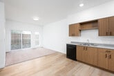 This single-floor residence offers a thoughtfully designed layout with a bright, open-concept living and dining area. The living space features light hardwood-style flooring that transitions to plush carpeting, and a sliding glass door with vertical blinds that fills the room with natural light while providing access to an outdoor view. Adjacent to the living area is a well-appointed kitchen outfitted with warm wood-tone cabinetry, light countertops, a clean white backsplash, and a full suite of black appliances including a refrigerator, electric range, over-the-range microwave, and dishwasher. Recessed lighting illuminates the kitchen, which also benefits from generous counter and cabinet space. The bedrooms are carpeted and comfortably sized, each featuring a window with vertical blinds that brings in natural light. One bedroom includes a spacious walk-in closet with wire shelving and hanging rods for ample storage. The unit includes two bathrooms: one features a wood-tone vanity with a light countertop and large mirror, while the other includes a full bathtub with a curved shower rod. Both bathrooms are finished with light hardwood-style flooring, maintaining a consistent and cohesive aesthetic throughout the space.