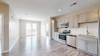 Located at 705 South 6th Street in Nashville's vibrant East Side, this 2-bedroom, 2-bathroom residence offers a thoughtfully designed single-floor layout with modern finishes throughout. Light gray luxury vinyl plank flooring flows consistently across the entire space, creating a clean, cohesive aesthetic.

The open-concept kitchen and dining area serves as the heart of the home, featuring gray shaker-style cabinetry, granite countertops, a white subway tile backsplash, and a full suite of stainless steel appliances including a range, microwave, dishwasher, and refrigerator. The adjacent living area is bathed in natural light from a set of French doors that open to a balcony with views of the Nashville skyline.

The primary bedroom includes an en-suite bathroom with a granite-topped dual vanity, gray cabinetry, and a glass-enclosed walk-in shower, as well as a spacious walk-in closet outfitted with wire shelving systems. The second bedroom is well-proportioned and features a closet with built-in shelving. The second bathroom offers a tiled tub-shower combo and matching granite vanity. Neutral warm-beige walls throughout give the space a calm, welcoming ambiance well-suited for modern urban living.