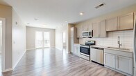 Located at 705 South 6th Street in Nashville's vibrant East Side, this 2-bedroom, 2-bathroom residence offers a thoughtfully designed single-floor layout with modern finishes throughout. Light gray luxury vinyl plank flooring flows consistently across the entire space, creating a clean, cohesive aesthetic.

The open-concept kitchen and dining area serves as the heart of the home, featuring gray shaker-style cabinetry, granite countertops, a white subway tile backsplash, and a full suite of stainless steel appliances including a range, microwave, dishwasher, and refrigerator. The adjacent living area is bathed in natural light from a set of French doors that open to a balcony with views of the Nashville skyline.

The primary bedroom includes an en-suite bathroom with a granite-topped dual vanity, gray cabinetry, and a glass-enclosed walk-in shower, as well as a spacious walk-in closet outfitted with wire shelving systems. The second bedroom is well-proportioned and features a closet with built-in shelving. The second bathroom offers a tiled tub-shower combo and matching granite vanity. Neutral warm-beige walls throughout give the space a calm, welcoming ambiance well-suited for modern urban living.
