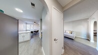 Located at 4650 W Oakey Blvd in Las Vegas, NV, this single-floor unit offers three bedrooms and three bathrooms within a efficiently designed layout. Light wood-style flooring flows throughout, complemented by neutral gray walls and textured ceilings that create a clean, contemporary aesthetic.

The kitchen is outfitted with white shaker cabinetry, quartz countertops, stainless steel appliances including a gas range, refrigerator, and dishwasher, and a peninsula that opens toward the dining area. A distinctive arched doorway connects the kitchen to the rest of the unit, adding a subtle architectural detail. The dining area features large corner windows with slatted blinds that invite natural light and a ceiling fan overhead.

The living room is bright and open, with a sliding glass door providing access to an outdoor area. Each of the three bedrooms is well-proportioned, with the spacious primary bedroom offering a generous footprint, a window for natural light, and easy access to closet space. The bathrooms are finished with white vanities, quartz countertops, and wood-style tile flooring, with one bathroom featuring a full tub-shower combination with white tile surround and brushed nickel fixtures throughout.