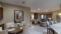 Located at 2001 S Voss Rd in Houston, TX, this thoughtfully designed single-floor residence offers a cohesive blend of comfort and sophistication. The open-concept living and dining area is finished with large-format porcelain tile flooring that extends throughout the main living spaces, creating a seamless, expansive feel. The dining area features a round wood table surrounded by upholstered chairs with nail-head trim, accented by a large decorative mirror and built-in display cabinetry. The living room is warmly styled with a tufted sofa, eclectic accent chairs, and bold artwork, while windows allow natural light and outdoor views to filter in. The kitchen is outfitted with rich dark wood cabinetry, granite countertops, a central island with pendant lighting, stainless steel appliances, and ample storage including a built-in wine rack. The bedrooms offer plush carpeting, generous closet space, and ceiling fans, while one bedroom includes a walk-in closet. The bathrooms are well-appointed, with one featuring a glass-enclosed walk-in shower with large-format tile, and another offering both a soaking tub and a separate glass shower. Warm neutral tones and curated décor lend the entire space an inviting, upscale ambiance throughout.