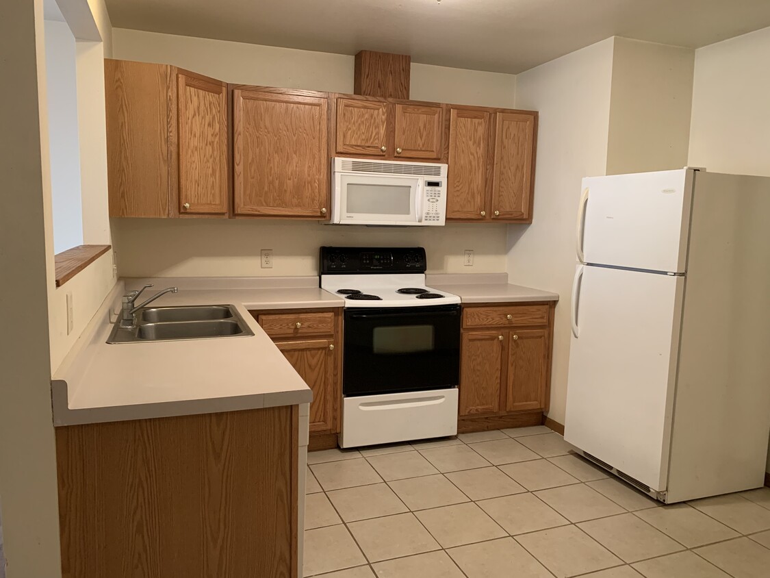 Kitchen with dishwasher, microwave and tile flooring. - 410 3rd St W