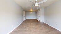 Located at 2816 Eden St in Pascagoula, Mississippi, this single-floor, 2-bedroom, 2-bathroom home offers a practical and comfortable layout throughout. The living room greets you with warm hardwood-style flooring, soft grey walls, and a ceiling fan with light fixture. French doors flood the space with natural light and provide outdoor access, creating an airy, welcoming atmosphere. The open living and dining area flows seamlessly into the galley-style kitchen, which features rich dark wood cabinetry, granite-look countertops, tile flooring, and black appliances including a range, microwave, and dishwasher, along with a stainless steel refrigerator and sink. Both bedrooms are carpeted and equipped with ceiling fans and windows with blinds that invite natural light. The primary bedroom is a comfortable size and includes a double-door closet. The two bathrooms are finished with warm earth-tone tile flooring. One bathroom features a full tub/shower combination with tile surround, while the other includes a rich wood vanity with granite-look countertop and a large mirror. A hallway connects the main living spaces, completing the efficient and cohesive floor plan of this Pascagoula home.