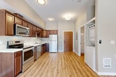 Located at 3129 Old Fairhaven Pkwy in Bellingham, WA, this efficiently designed unit offers a well-organized single-floor layout that makes smart use of its space. The open-concept kitchen and living area serves as the heart of the unit, featuring rich dark-wood cabinetry with ample storage, light-toned countertops, and a full suite of stainless steel appliances including a range, microwave, dishwasher, and refrigerator. Light hardwood-style flooring runs throughout, lending warmth and visual continuity across every room. The living area is bright and airy, benefiting from a ceiling fan and a large sliding glass door that floods the space with natural light and provides direct access to an outdoor patio with views of the surrounding property. A stacked washer and dryer unit is conveniently tucked into a dedicated nook, adding in-unit laundry functionality. The closet features elegant double panel doors, offering organized storage. The bathroom is clean and functional, complete with a full soaking tub and shower combination. Neutral wall tones throughout create a calm, versatile backdrop. The unit's thoughtful design and modern finishes make it a practical and comfortable residence in the Fairhaven area of Bellingham.