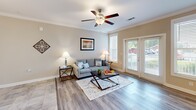 This single-story residence at 920 Seasons Dr in Gastonia, North Carolina, offers a well-designed layout that balances comfort and functionality. The open-concept living area features wood-look flooring, crown molding, and a ceiling fan, creating a bright and welcoming atmosphere. French doors with slatted blinds allow natural light to fill the room while providing access to the outdoors. Adjacent to the living area, the dining space features tile flooring and chair-rail molding, adding a classic touch to the interior. The kitchen is equipped with dark espresso cabinetry, granite countertops, stainless steel appliances, and a peninsula with bar seating, illuminated by pendant lighting overhead. Both bedrooms offer wood-look flooring and ample natural light, with one featuring a large window and a pendant light fixture. Each bedroom benefits from generous closet space, including a spacious walk-in closet with wire shelving and hanging rods. A dedicated laundry area with washer and dryer hookups adds convenience. The bathroom showcases granite countertops, dark cabinetry, and a tub-shower combination with tile surround. Neutral tones and clean finishes throughout give the home a polished, move-in-ready appeal.