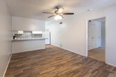 This single-story home in Lubbock, Texas offers a well-designed, functional layout with a variety of attractive finishes throughout. The entryway welcomes visitors with terra cotta tile flooring and sidelight windows flanking the front door, allowing natural light to filter in from the exterior. The open-concept living and dining area features warm hardwood-style plank flooring and a ceiling fan with integrated lighting, creating a bright and comfortable gathering space. The kitchen is a standout, equipped with white cabinetry, gray laminate countertops, a textured stone tile backsplash, a breakfast bar peninsula, and white appliances including a range and dishwasher. Terra cotta tile flooring carries through the kitchen, providing a cohesive transition from the entry. The bedroom is generously sized, featuring plush carpet, two closets offering ample storage, and a ceiling fan. The bathroom is well-appointed with dual vanity sinks, gray countertops, white cabinetry with drawers, a full tub and shower combination, and matching terra cotta tile flooring. Textured ceilings are present throughout the home, adding classic character. Overall, the space presents a clean, move-in ready environment with consistent, practical finishes.