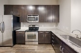 This contemporary 1400 square foot apartment in Charlotte, NC offers a harmonious blend of style and functionality. The open-concept floor plan seamlessly integrates the living spaces, creating a fluid and spacious feel. The gourmet kitchen is a standout feature, boasting sleek dark wood cabinetry, stainless steel appliances, and elegant granite countertops. Pendant lighting adds a touch of modern flair.

The three bedrooms provide ample space for rest and relaxation, with the primary bedroom measuring a generous 180 square feet. Two well-appointed bathrooms feature granite vanities, large mirrors, and a combination of shower and bathtub options. The apartment's design maximizes natural light with large windows, while ceiling fans ensure comfort throughout.

Storage is abundant with three closets and a dedicated laundry area. The neutral color palette, including soft beige walls and plush carpeting in bedrooms, creates a versatile backdrop for any decor style. Hardwood-style flooring in the kitchen adds warmth and durability.

This single-story apartment combines modern amenities with thoughtful design, offering a comfortable and stylish living space in the heart of Charlotte.