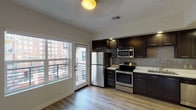 Located on the fifth floor at 450 10th in San Diego, Unit #509 is a thoughtfully designed single-level residence that blends modern aesthetics with everyday functionality. The open living area is bathed in natural light through large windows and offers direct access to a private balcony via a glass-paned door, providing views of the surrounding urban neighborhood. Light-toned hardwood-style flooring flows seamlessly throughout the space, creating a clean and cohesive look. The kitchen is a standout feature, showcasing rich dark espresso cabinetry paired with crisp white countertops and a neutral tile backsplash. A full suite of stainless steel appliances — including a refrigerator, electric range, over-the-range microwave, and dishwasher — equips the space for serious cooking. Recessed lighting above the kitchen adds a polished, modern touch. The bedroom is a calm, well-lit retreat with its own access to the balcony, ceiling fan, and ample natural light from a large window. The bathroom features a full soaking tub and shower combination enclosed by subtly textured gray tile surround and brushed nickel fixtures, lending a clean, spa-like feel. Overall, this unit offers a refined and functional urban living experience in the heart of San Diego.