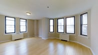 Situated in the heart of Philadelphia's prestigious Rittenhouse Square neighborhood, this single-floor space at 135 South 19th Street offers a clean, open layout designed to maximize comfort and functionality. The main living area is highlighted by smooth light hardwood flooring that runs throughout, lending warmth and a sense of continuity to the space. Neutral-toned walls complement the bright, understated aesthetic, creating a versatile backdrop suited to a variety of interior styles. A standout feature of the space is its generous windowed perimeter, with multiple large, black-framed windows arranged across two walls, including a distinctive bay-style corner configuration. These windows invite an abundance of natural light and offer views of the surrounding urban cityscape, making the space feel open and connected to the vibrant neighborhood outside. Radiator heating units positioned beneath the windows ensure year-round comfort. The ceiling is smooth and well-proportioned, fitted with a centrally placed flush-mount light fixture. The overall ambiance is bright, neutral, and move-in ready, offering a solid foundation in one of Philadelphia's most sought-after urban locations.