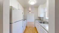 Located at 1450 Creekside Dr in Walnut Creek, CA, this one-bedroom, one-bathroom residence offers a practical and well-appointed single-floor layout. The galley-style kitchen is outfitted with white cabinetry, granite-style countertops, a stainless steel sink, and white appliances including a refrigerator, oven/range, and dishwasher. Light wood flooring runs throughout the kitchen, which opens toward the dining area, where a ceiling fan adds comfort and airflow. The dining room connects smoothly to the main living areas, creating an efficient flow throughout the home. The bedroom is generously sized, featuring plush wall-to-wall carpeting, a sliding door closet, and direct access to a private balcony that brings in natural light and outdoor views. The full bathroom is finished with matching granite-style countertops, white cabinetry, a combined shower/tub, and warm wood-tone flooring. A hallway connects the key spaces of the home, enhancing privacy between the living and sleeping areas. A separate entry area with a sliding glass door and vertical blinds provides additional balcony access and natural light. The overall design is clean, bright, and functional, making efficient use of the available space.