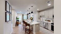 Located in Port Wentworth, Georgia, this thoughtfully designed 2-bedroom, 3-bathroom residence offers a cohesive blend of modern aesthetics and functional living across a single floor. Light wood-look flooring flows throughout, tying each room together seamlessly.

The kitchen is a standout feature, showcasing gray shaker-style cabinetry, white quartz countertops, a subway tile backsplash, and a full suite of stainless steel appliances. A generous island with seating serves as the centerpiece, illuminated by stylish pendant lights and recessed ceiling fixtures.

The adjoining living room is bright and welcoming, with large windows allowing ample natural light and providing access to an outdoor balcony. Ceiling fans are present throughout the home, adding comfort to each room.

The primary bedroom is spacious and serene, featuring a distinctive blue accent wall, ceiling fan, and direct access to a dedicated closet and an en-suite bathroom. The primary bath is elegantly finished with a dual-sink vanity with gray cabinetry, white countertops, and a glass-enclosed walk-in shower. The second bedroom mirrors the same warm, inviting aesthetic with a matching blue accent wall and natural light from a large window. Three full bathrooms ensure convenience and privacy for all occupants.