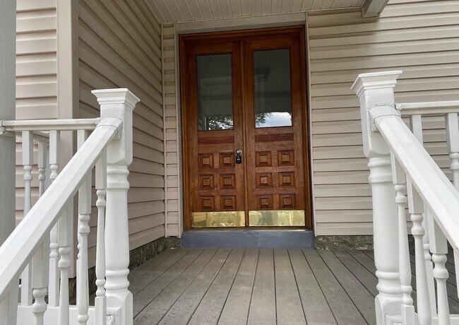 Entrada principal acogedora con preciosas puertas dobles de madera maciza y un porche cubierto. - 453 Lancaster Ave