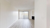 Located at 825 S Hobart Blvd in Los Angeles, CA, this 2-bedroom, 2-bathroom unit offers a thoughtfully designed single-floor layout. The living room is a bright, open space anchored by a fireplace and a floor-to-ceiling sliding glass door that fills the room with natural light and provides access to outdoor views. Built-in wall shelving adds a functional architectural detail to the living area. Light wood-style flooring and a textured ceiling run consistently throughout, creating a cohesive and clean aesthetic.

The kitchen features white cabinetry, granite-style countertops, and a stainless steel range, offering ample storage and counter space. Both bedrooms are generously proportioned, with the primary bedroom offering built-in sliding-door closets and multiple windows dressed with vertical blinds. The second bedroom also benefits from natural light through its windows.

Each of the two bathrooms is finished with matching granite-style vanity countertops, white cabinetry, and a tub-shower combination with sliding glass doors. Two hallways connect the rooms efficiently throughout the layout. The unit's neutral color palette, consistent flooring, and practical finishes create a clean, move-in ready environment well-suited for comfortable urban living in the heart of Los Angeles.
