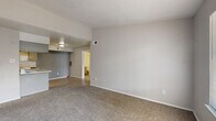 Located at 2909 Hayes Rd in Houston, TX, this single-floor residence offers a practical and well-organized layout with two bedrooms and two full bathrooms. The living area features neutral-toned carpet and connects seamlessly to the kitchen, which is outfitted with light wood-style flooring, gray cabinetry, granite-look countertops, a double basin sink, and black appliances including a refrigerator, range, microwave, and dishwasher. The galley-style kitchen provides ample counter and cabinet storage for everyday cooking needs. Both bedrooms are carpeted and include ceiling fans for added comfort. The spacious primary bedroom features two closets, including a generous walk-in closet with built-in shelving and hanging rods. The second bedroom also offers closet access and a window that brings in natural light. Each bathroom includes a tub-shower combination with white tile surround. One bathroom features wood-style flooring and a granite-look vanity countertop, while the other offers a clean, all-white aesthetic. Throughout the space, a consistent neutral color palette and clean finishes create a cohesive and move-in-ready atmosphere well-suited for comfortable everyday living.