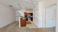 Located at 6700 W Memorial Rd in Oklahoma City, Oklahoma, this single-floor residence offers a well-designed open-concept layout that seamlessly connects the main living areas. The kitchen is a standout feature, showcasing rich dark wood cabinetry, granite countertops, and a full suite of stainless steel appliances including a range, microwave, and dishwasher. A peninsula with pendant lighting serves as both a functional workspace and a natural dividing point between the kitchen and the carpeted living area, which benefits from multiple windows that invite abundant natural light. The living space is generously proportioned, with neutral-toned carpet and easy access to an exterior door. The bedroom features plush carpeting, a ceiling fan, and a window with a view to the outside, creating a comfortable and well-lit retreat. Closet space is thoughtfully integrated into the layout. The bathroom is finished with warm stone-look tile flooring and wall surround, and includes both a soaking tub and a separate tiled shower. Throughout the residence, a consistent neutral color palette and clean white trim lend a cohesive, move-in-ready aesthetic. Tile flooring in the entry and kitchen provides durability, while carpeted rooms add warmth and comfort to the overall living experience.