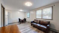 Located at 380 Daleville Rd in Willington, CT, this efficient one-bedroom, one-bathroom unit is thoughtfully laid out across a single floor. Light-toned hardwood-style flooring runs throughout the entire space, creating a cohesive and easy-to-maintain interior.

The combined living and dining area forms the heart of the unit, offering enough room for a full sofa and a four-seat dining set. Multiple windows fitted with horizontal blinds allow natural light to filter in, while baseboard heating provides reliable warmth. A paneled entry door with a transom window adds a classic touch to the entryway.

The kitchen is compact yet functional, featuring white cabinetry, a mosaic tile backsplash, a freestanding electric range, and a full-size refrigerator — providing all the essentials for everyday cooking.

The bedroom is a comfortable and quiet retreat, offering a window with outdoor views of surrounding greenery, a built-in closet with shelving and a hanging rod, and soft neutral wall tones that contribute to a calm atmosphere.

The bathroom is clean and straightforward, with a tub/shower combination, a toilet, and a vanity, finished with neutral tile flooring. This unit offers a practical and well-organized layout suited for single occupancy or couples seeking a simple, functional living space.