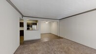 This 1-bedroom, 1-bathroom residence is thoughtfully laid out across a single floor, encompassing six distinct areas: a living room, dining room, kitchen, bedroom, bathroom, and hallway. The open living and dining area features warm carpet flooring, a textured ceiling, crown molding, a ceiling fan with light fixture, and a set of French doors that invite natural light and provide outdoor access. A pass-through window connects the living area to the kitchen, which is outfitted with dark espresso cabinetry, a white subway tile backsplash, granite-look countertops, wood-look vinyl plank flooring, and stainless steel appliances including a refrigerator, dishwasher, and range. The bedroom is a comfortable, carpeted retreat with a large window for natural light. The bathroom features a dark-framed vanity mirror, granite countertop, undermount sink, dark cabinetry with brushed nickel hardware, and tile flooring. Throughout the unit, a neutral color palette of soft whites and warm grays creates a clean, cohesive aesthetic. The combination of carpet in living and sleeping areas alongside wood-look vinyl in the kitchen and dining room adds both warmth and practicality to the overall design.