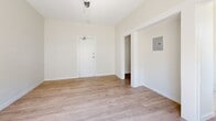 Located at 147 N New Hampshire Ave in the heart of Los Angeles, CA, this efficiently designed single-floor unit offers a well-organized layout comprising a living room, kitchen, hallway, and bathroom. The interior is finished with light wood-style flooring and crisp white walls throughout, creating a clean, cohesive aesthetic.

The living room is an open, airy space bathed in natural light from a large window, offering a bright and welcoming atmosphere. A utility panel is neatly mounted on the wall, and the room connects seamlessly to the rest of the unit via a central hallway.

The kitchen is thoughtfully appointed with white upper and lower cabinetry, speckled quartz-style countertops, a stainless steel gas range with overhead ventilation, and a sink positioned beneath a window that allows natural light to fill the space. A refrigerator is also included, visible from the adjacent hallway.

The bathroom features white subway tile surrounding the bathtub and shower area, a standard toilet, a window for natural ventilation, and brushed nickel hardware accents including towel bars and a towel ring. The wood-style flooring continues into this space, maintaining a consistent finish throughout the unit.

Overall, the space presents a functional, light-filled environment with a neutral and modern aesthetic, well-suited for urban living in Los Angeles.